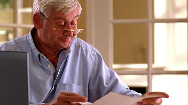 Man looking at paper with reading glasses